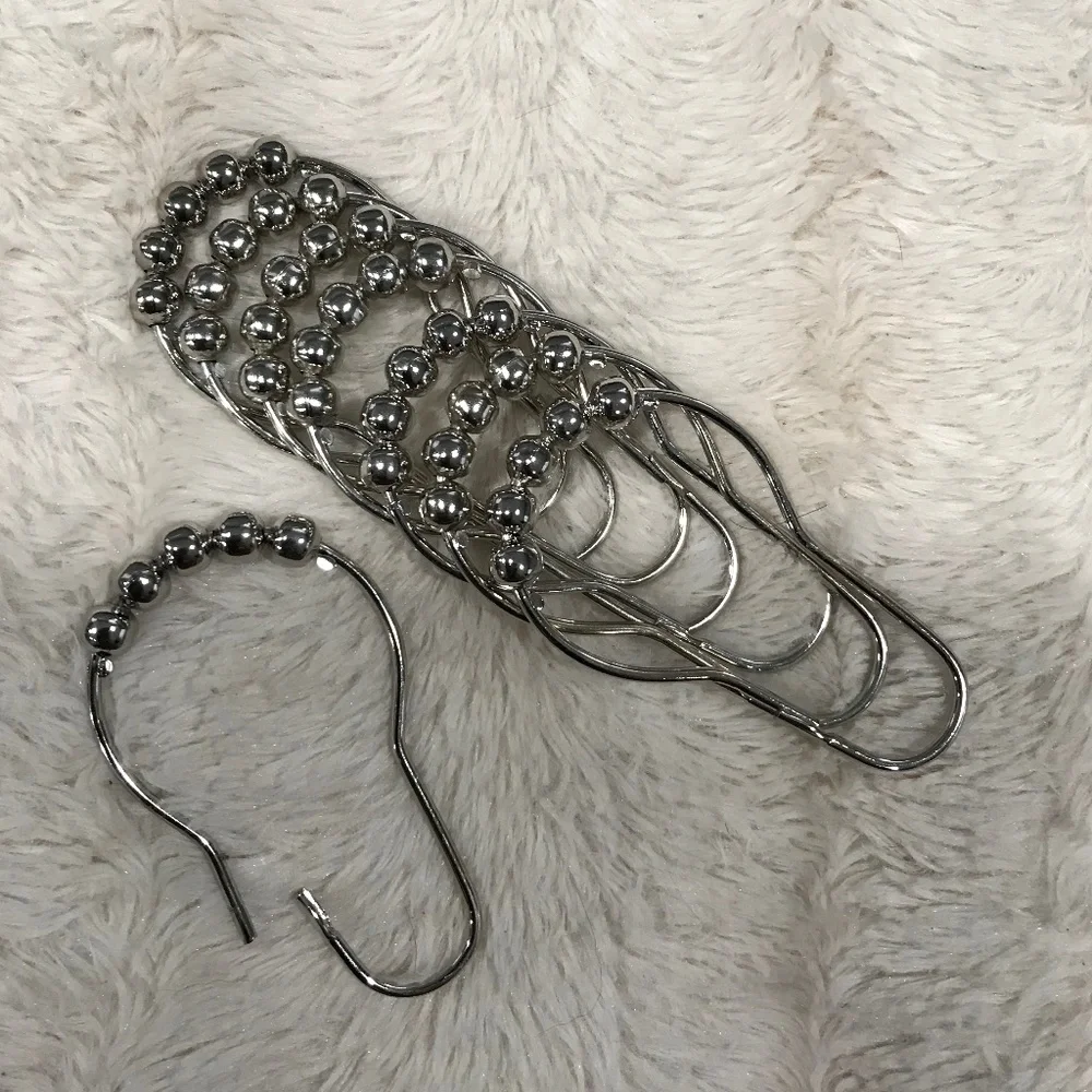 Metal hooks and bathroom shower curtain.